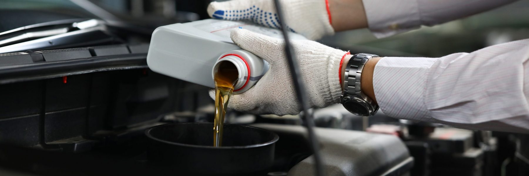 Foreman pours engine oil into engine. Car service concept